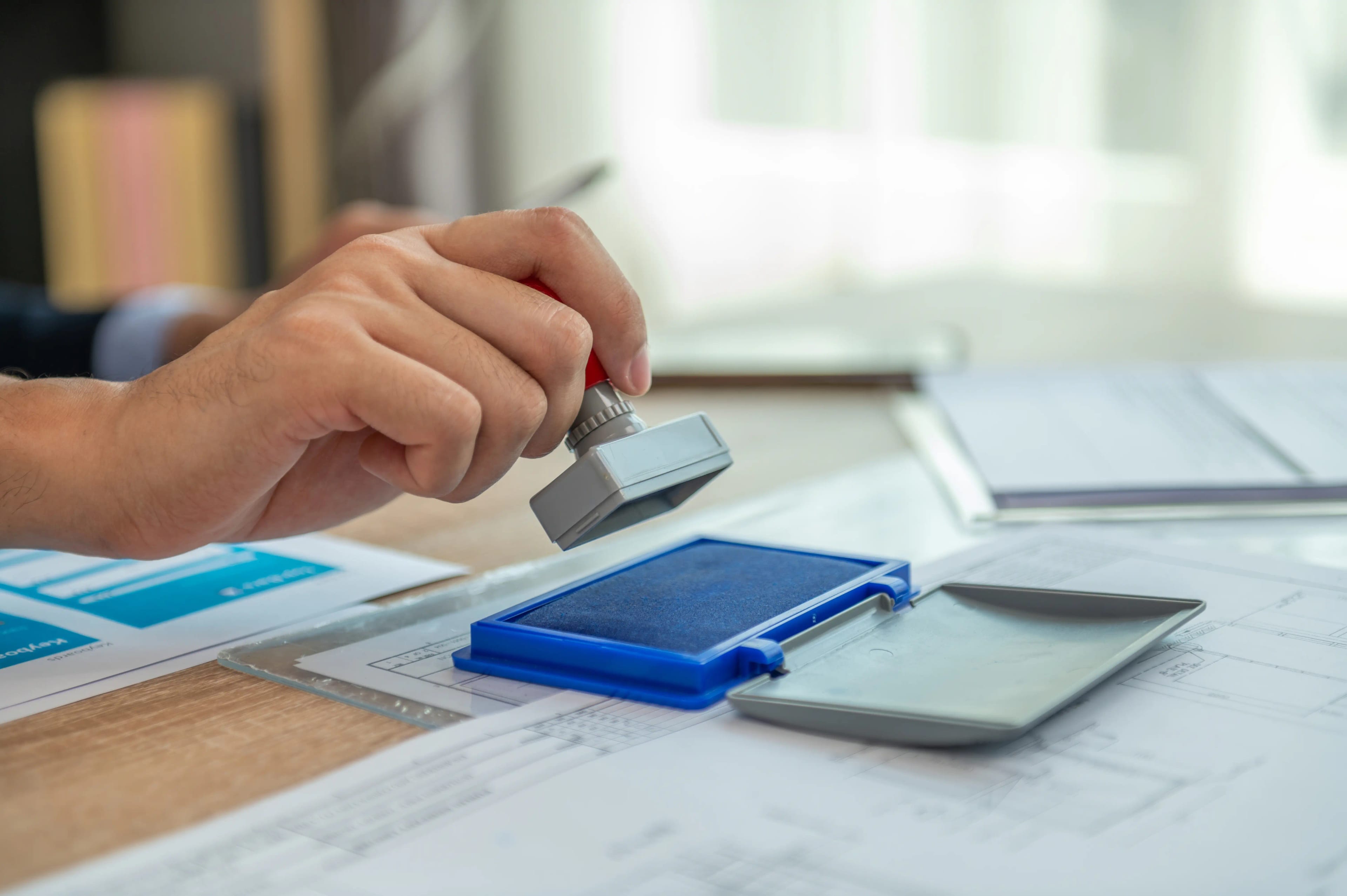 A,Person,Stamping,A,Document,With,A,Rubber,Stamp.